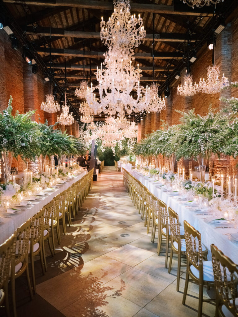 Luxury Chicago wedding design reception with crystal chandeliers, greenery and long banquet tables even desig Rishi the Designer