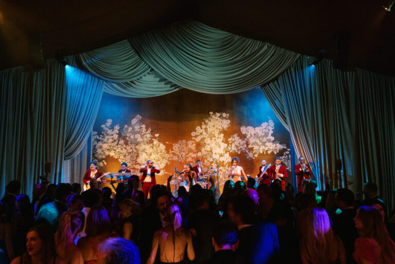 Wedding dance floor design with blue draping, dramatic lighting and floral stage design wedding designer HMR Designs