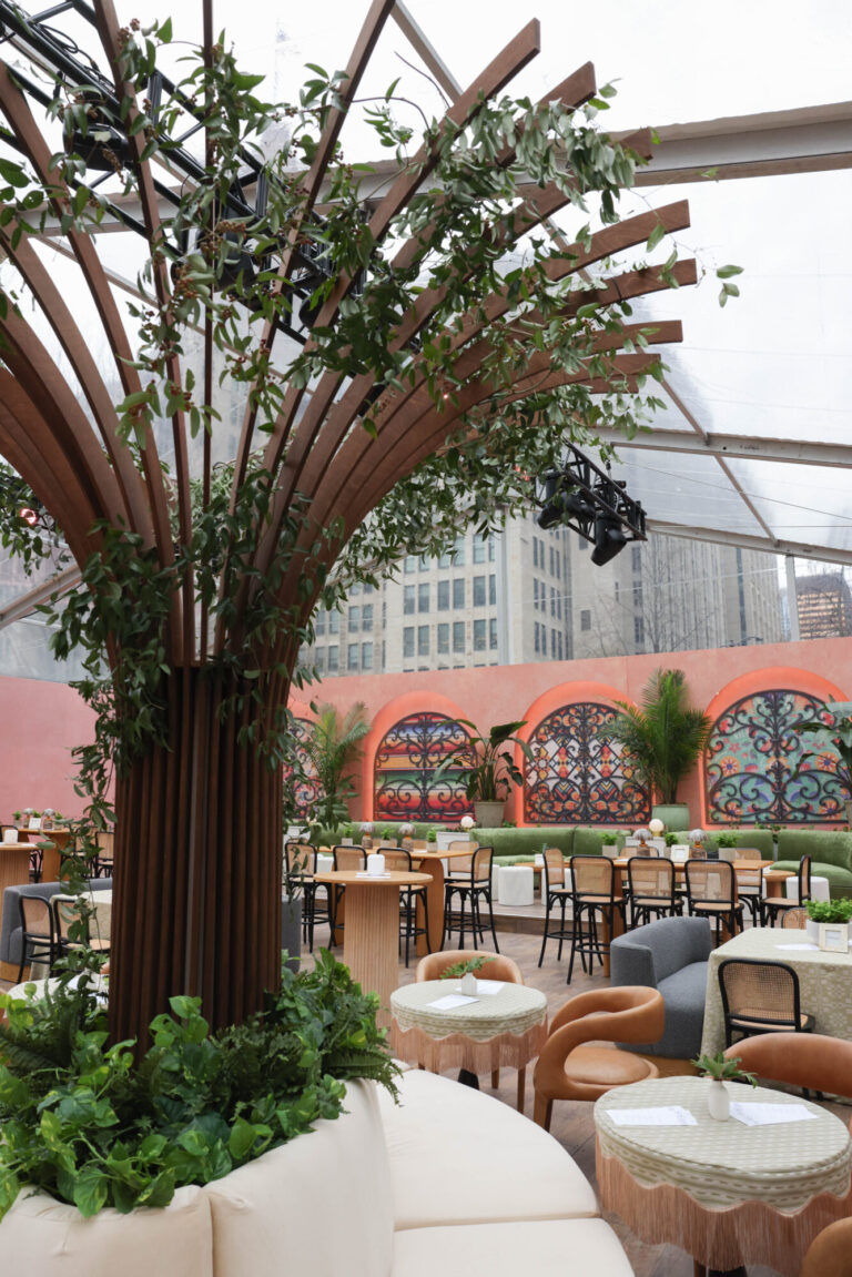 Colorful clear tent corporate event with sculptural wooden tree installation, mosaic arch backdrop, and mixed lounge seating in Chicago