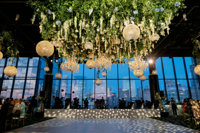 Luxury Chicago wedding reception head table with tall golden floral tree centerpieces, orange and rust floral arrangements, and city skyline views