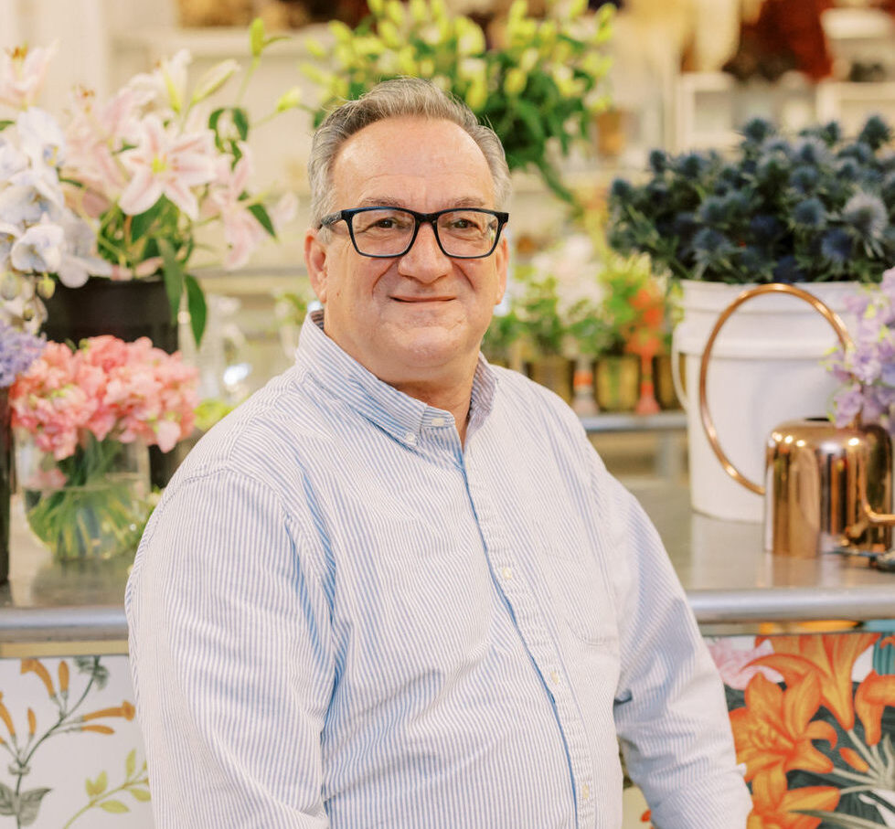 Michael Martin, Mock-Up Floral Designer at HMR Designs, smiling among florals