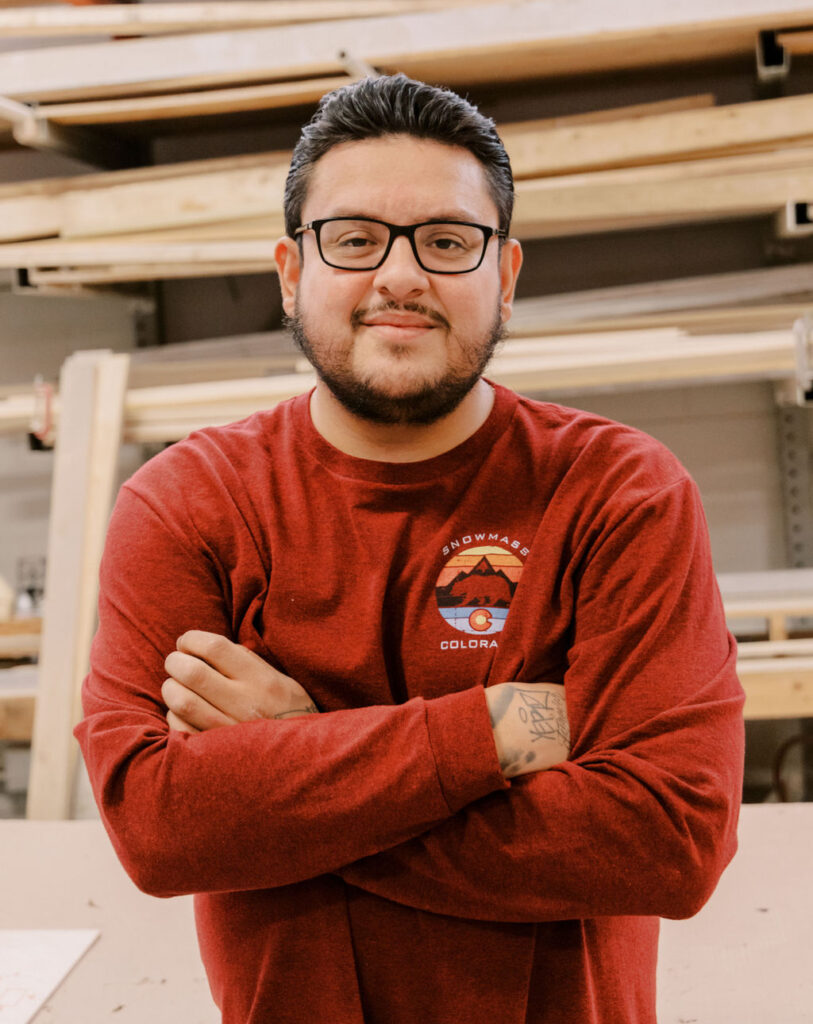 Luis Loredo, Dismantle Lead at HMR Designs, smiling in the warehouse