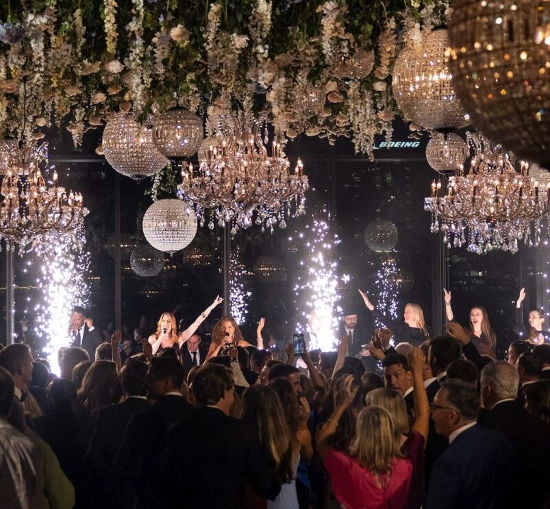 Luxury wedding reception with suspended floral installations, chandeliers and dramatic event lighting