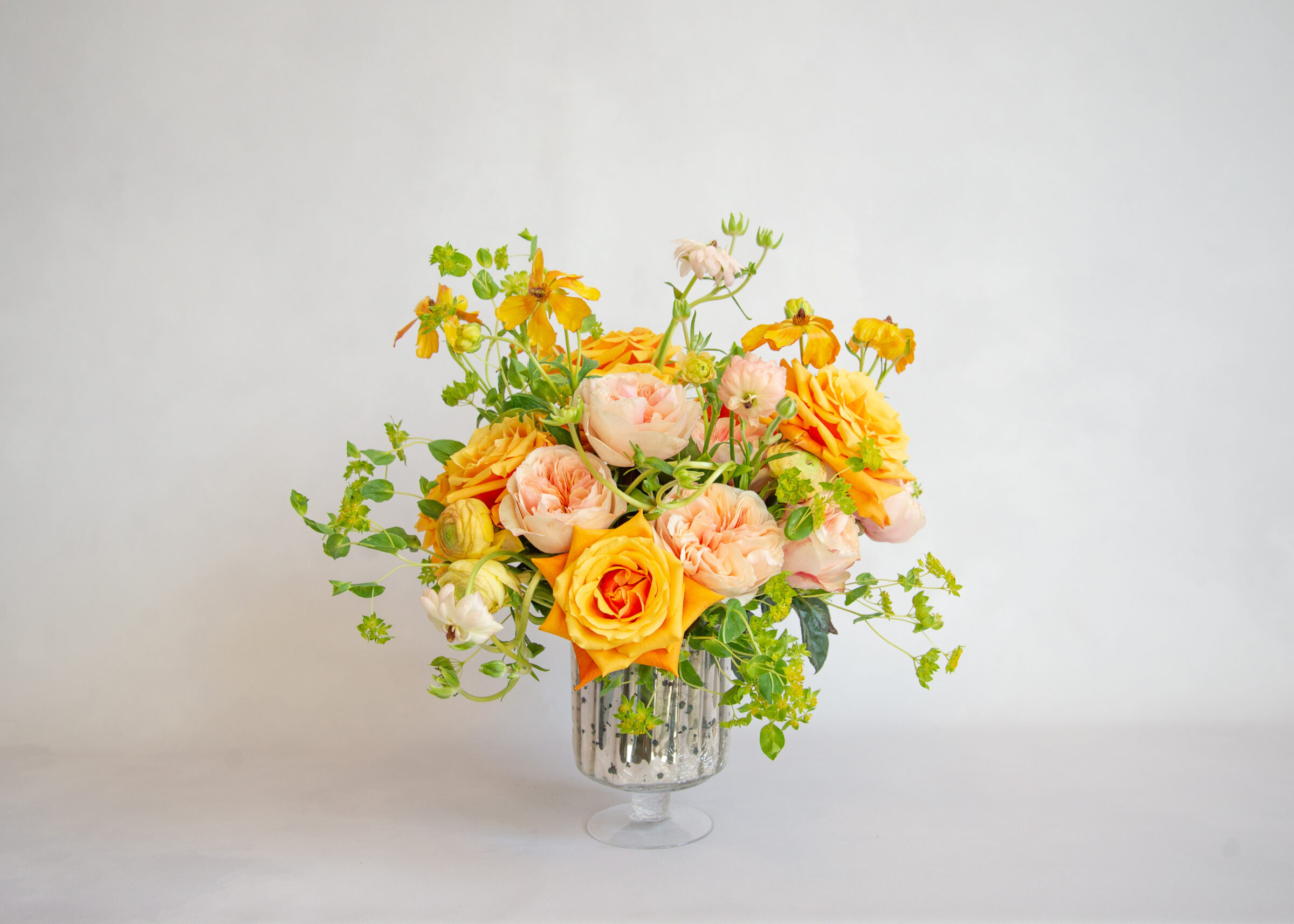 Citrus Delight floral arrangement with orange roses, peach garden roses, and yellow wildflowers by HMR Designs