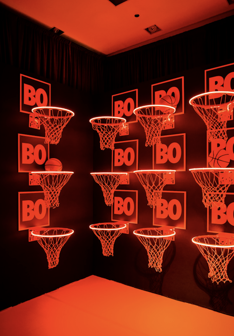 Chicago suburbs bar mitzvah designer Rishi Patel created a red basketball installation with custom hoops and neon graphics for HMR Designs