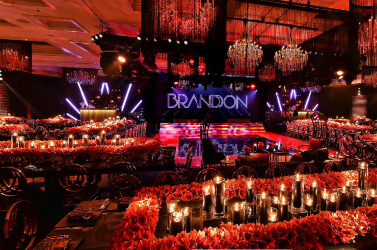 Chicago bar mitzvah designer Rishi Patel created a custom Brandon stage with concert lighting and red floral décor for HMR Designs