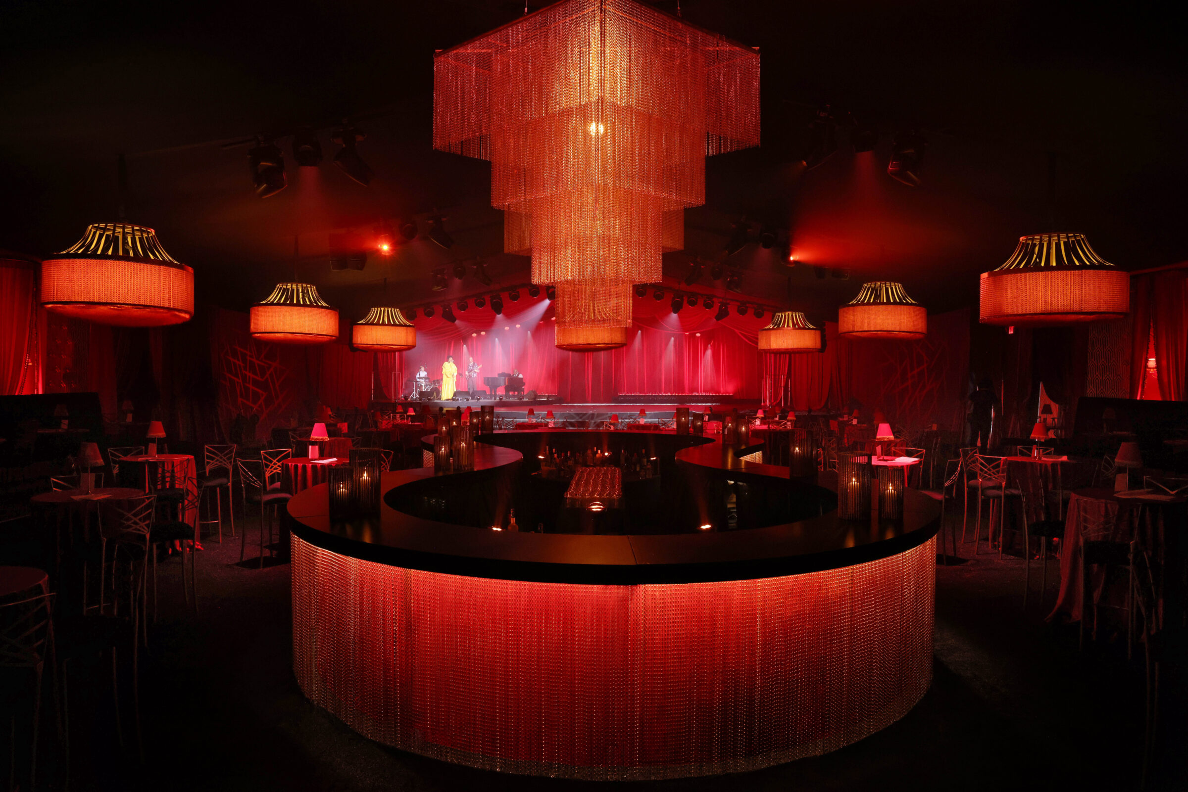 Circular event bar with red lighting and large suspended chandelier